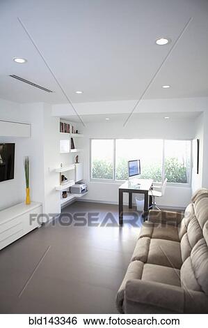Stock Photograph - Sofa, coffee table and windows in modern living room. Fotosearch