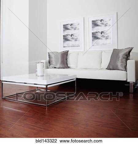 Stock Image - Sofa, wall art and coffee table in modern living room. Fotosearch
