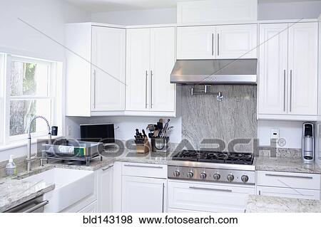 Stove, cabinets and sink in modern kitchen View Large Photo Image Stock Photo - Stove, cabinets and sink in modern kitchen. Fotosearch