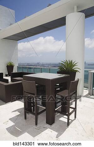 Stock Image - Table and chairs on modern balcony. Fotosearch