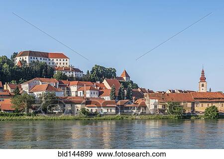 Stock Photo - Village buildings on hillside near lake. Fotosearch