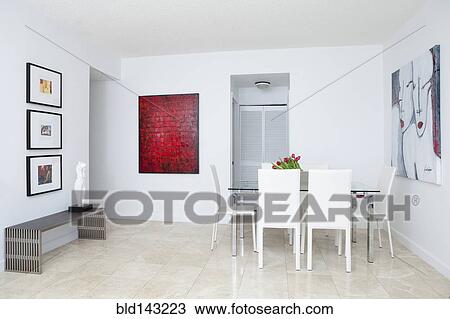 Stock Image - Wall art, table and chairs in modern dining room. Fotosearch