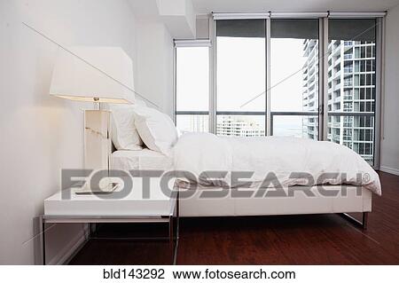 Windows, night table and bed in modern bedroom View Large Photo Image Stock Image - Windows, night table and bed in modern bedroom. Fotosearch