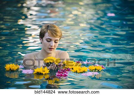 Picture - Woman playing with flowers in lake. Fotosearch
