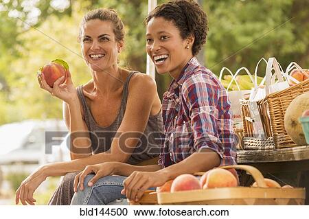 Women laughing at farmers market View Large Photo Image Stock Image - Women laughing at farmers market. Fotosearch