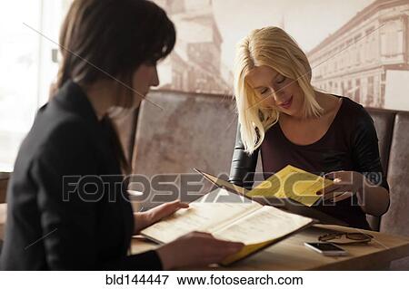 Stock Photo - Women reading menus in cafe. Fotosearch