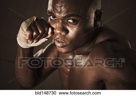 Stock Image - African American boxer preparing to punch. Fotosearch