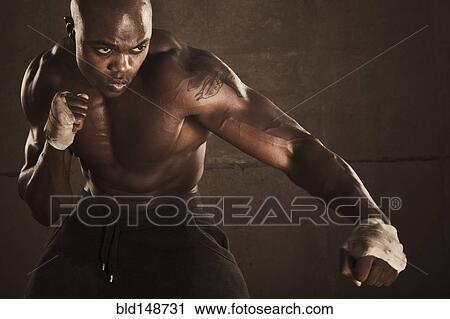 Stock Image - African American boxer preparing to punch. Fotosearch