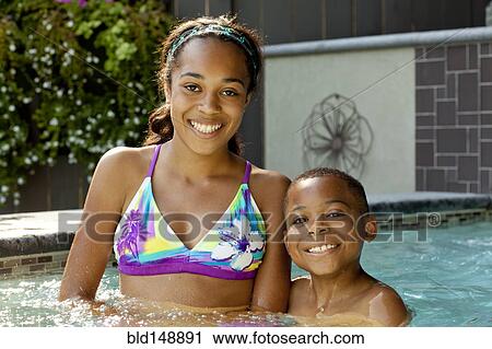 Stock Image - African American children enjoying swimming pool. Fotosearch