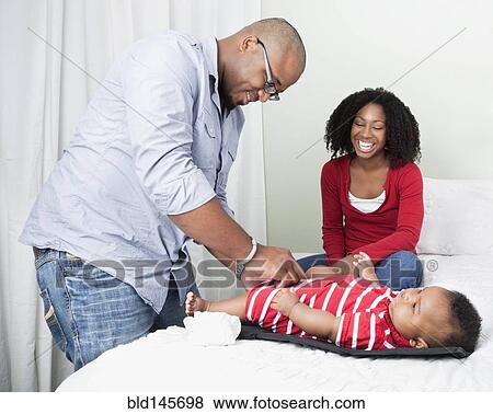 African American father changing baby son's diapers View Large Photo Image Stock Photo - African American father changing baby son's diapers. Fotosearch