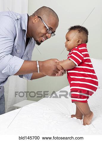 African American father helping baby son to stand up View Large Photo Image Stock Image - African American father helping baby son to stand up. Fotosearch