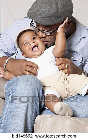 African American holding and kissing baby son in lap View Large Photo Image Stock Image - African American holding and kissing baby son in lap. Fotosearch