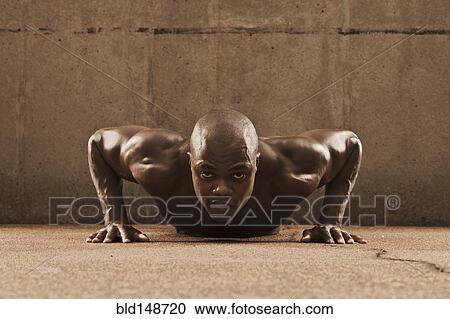 Stock Image - African American man doing push-ups. Fotosearch