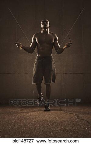 Stock Photo - African American man jumping rope. Fotosearch