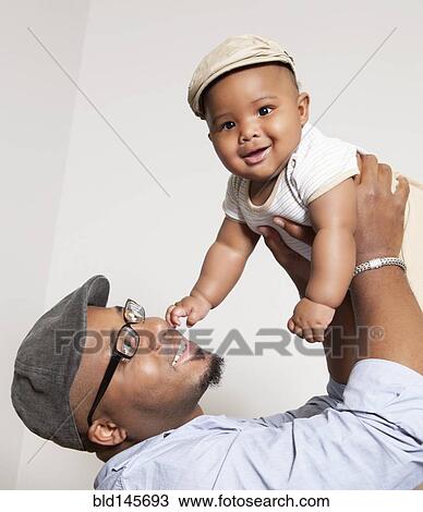African American man lifting baby son into the air View Large Photo Image Stock Image - African American man lifting baby son into the air. Fotosearch