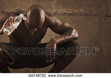 African American man pouring water over himself after exercise View Large Photo Image Stock Image - African American man pouring water over himself after exercise. Fotosearch