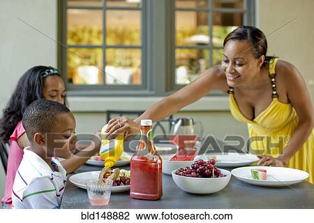 Stock Image - African American mother preparing lunch for children. Fotosearch
