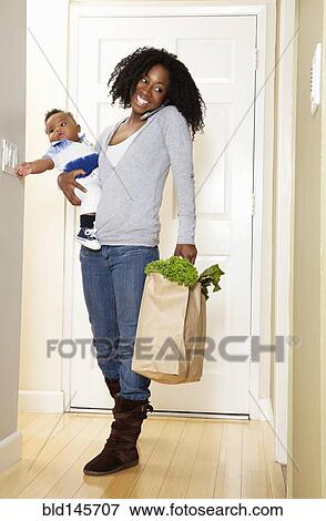 African American woman carrying bag of groceries. baby son and talking on phone View Large Photo Image Stock Photo - African American woman carrying bag of groceries. baby son and talking on phone. Fotosearch