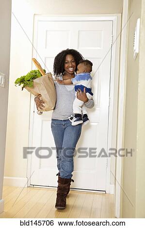 African American woman carrying bag of groceries and baby son View Large Photo Image Stock Photograph - African American woman carrying bag of groceries and baby son. Fotosearch