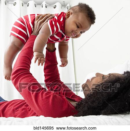 African American woman lifting baby son into the air View Large Photo Image Stock Photography - African American woman lifting baby son into the air. Fotosearch
