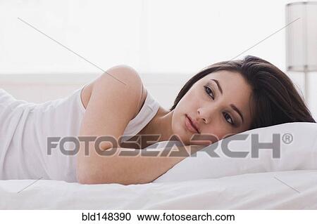 Alluring mixed race woman laying in bed View Large Photo Image Stock Image - Alluring mixed race woman laying in bed. Fotosearch
