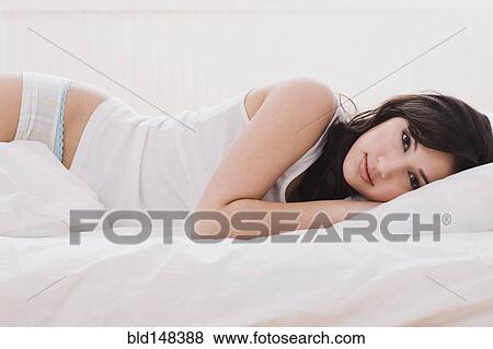 Alluring mixed race woman laying in bed View Large Photo Image Stock Photo - Alluring mixed race woman laying in bed. Fotosearch