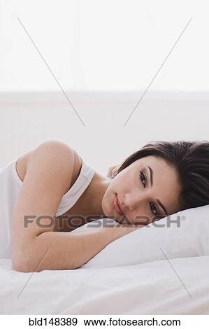 Alluring mixed race woman laying in bed View Large Photo Image Stock Photo - Alluring mixed race woman laying in bed. Fotosearch