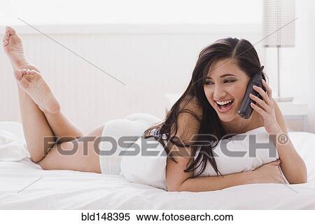 Alluring mixed race woman laying in bed talking on telephone View Large Photo Image Stock Photography - Alluring mixed race woman laying in bed talking on telephone. Fotosearch