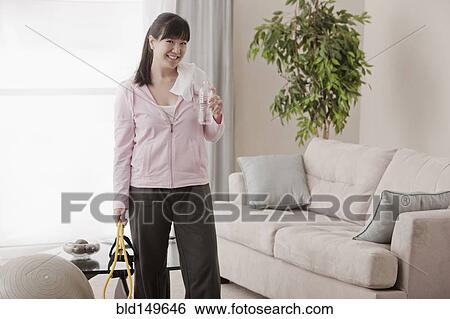 Stock Photograph - Asian woman relaxing after exercise. Fotosearch