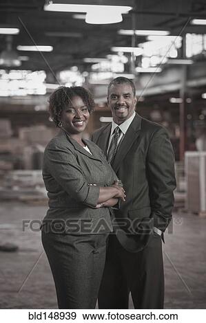 Stock Photo - Black business people standing in warehouse. Fotosearch