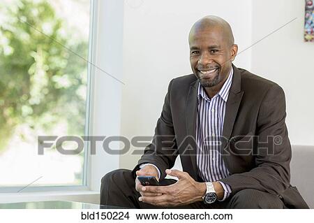 Black businessman text messaging on cell phone View Large Photo Image Picture - Black businessman text messaging on cell phone. Fotosearch