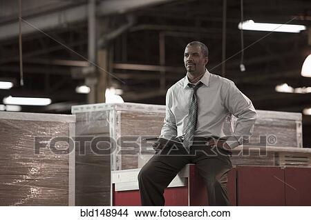 Black businessman working in warehouse View Large Photo Image Picture - Black businessman working in warehouse. Fotosearch
