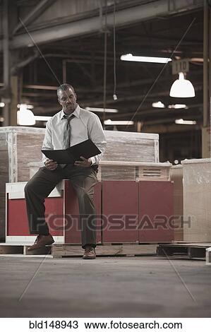 Black businessman working in warehouse View Large Photo Image Stock Image - Black businessman working in warehouse. Fotosearch
