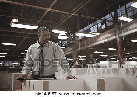Black businessman working in warehouse View Large Photo Image Stock Photo - Black businessman working in warehouse. Fotosearch
