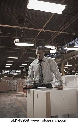 Black businessman working in warehouse View Large Photo Image Stock Photo - Black businessman working in warehouse. Fotosearch