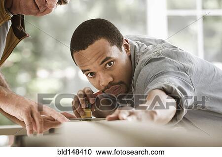 Black carpenter measuring lumber View Large Photo Image Stock Image - Black carpenter measuring lumber. Fotosearch