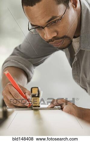 Black carpenter measuring lumber View Large Photo Image Stock Photo - Black carpenter measuring lumber. Fotosearch