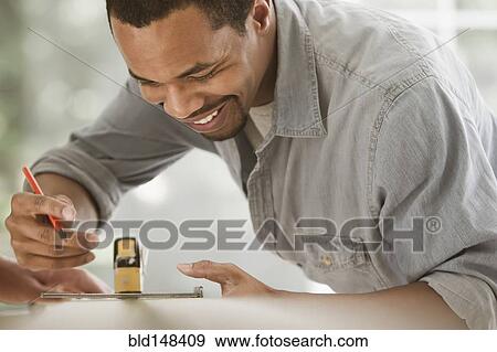 Black carpenter measuring lumber View Large Photo Image Stock Photo - Black carpenter measuring lumber. Fotosearch