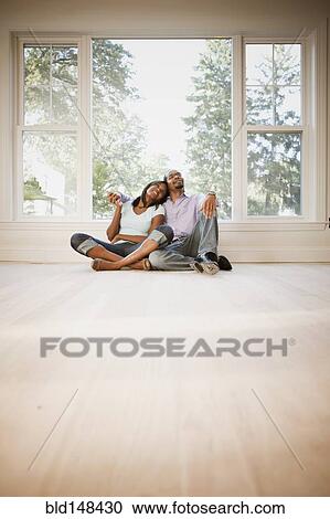 Black couple sitting on floor of empty room View Large Photo Image Stock Image - Black couple sitting on floor of empty room. Fotosearch
