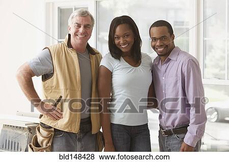Black couple standing with carpenter View Large Photo Image Stock Photo - Black couple standing with carpenter. Fotosearch