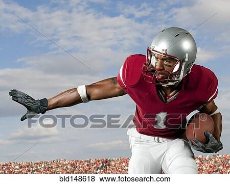Black football player holding football View Large Photo Image Stock Photo - Black football player holding football. Fotosearch