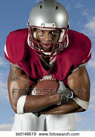 Black football player holding football View Large Photo Image Stock Photo - Black football player holding football. Fotosearch