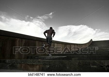 Stock Image - Black man running up stairs. Fotosearch
