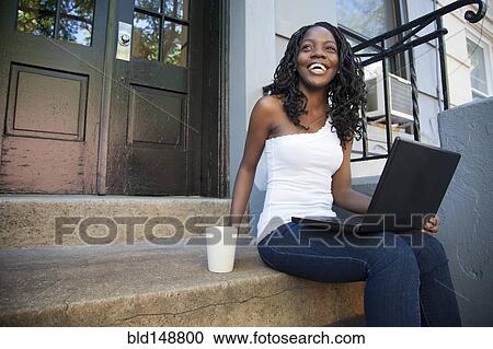 Black woman using laptop on front stoop View Large Photo Image Stock Image - Black woman using laptop on front stoop. Fotosearch