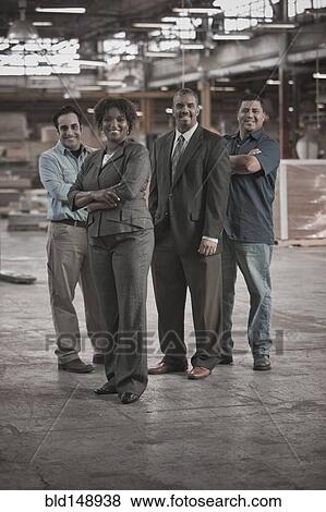 Business people and workers standing in warehouse View Large Photo Image Stock Photo - Business people and workers standing in warehouse. Fotosearch