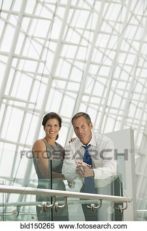 Stock Photography - Business people leaning on railing. Fotosearch