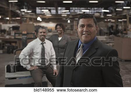 Stock Photography - Business people standing in warehouse. Fotosearch