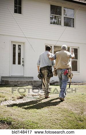 Stock Photo - Carpenters walking toward house. Fotosearch