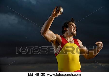 Stock Image - Caucasian athlete throwing shot put. Fotosearch