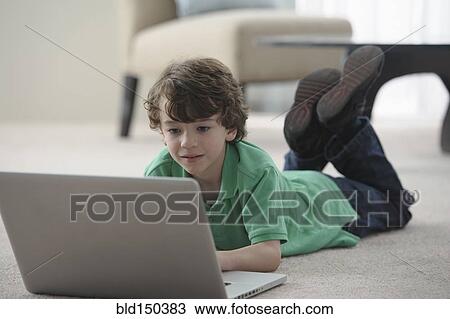 Caucasian boy laying on floor using laptop View Large Photo Image Stock Image - Caucasian boy laying on floor using laptop. Fotosearch